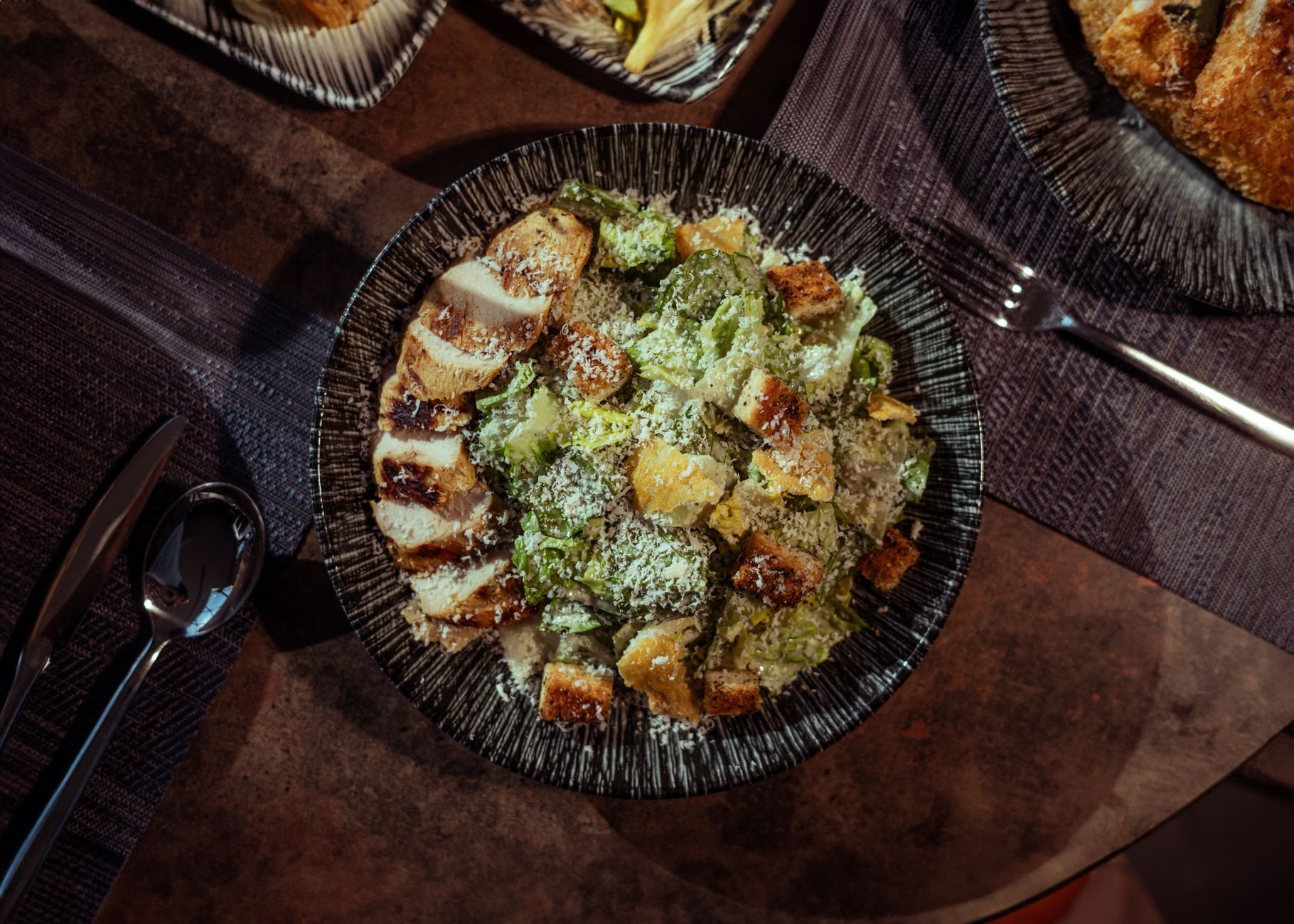 Appetizing Caesar salad with grilled chicken, croutons, and Parmesan cheese, perfect for a gourmet meal.