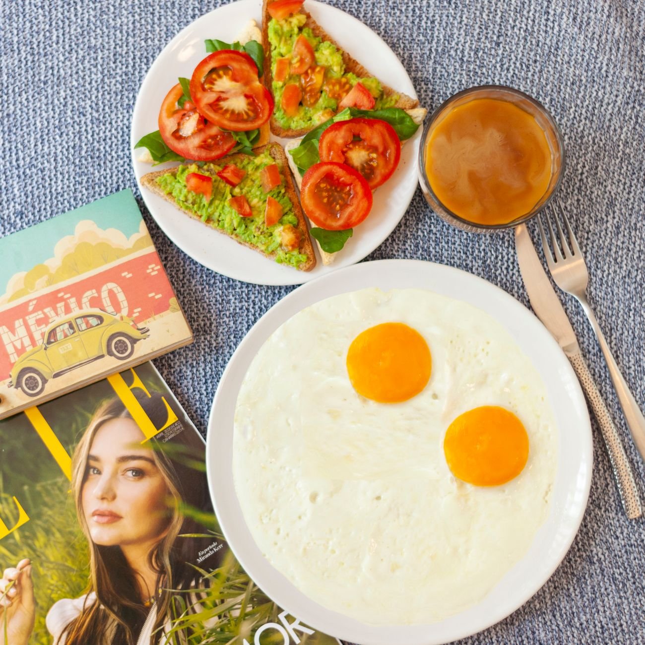 Delicious flat lay of breakfast with avocado toast, eggs, and coffee.